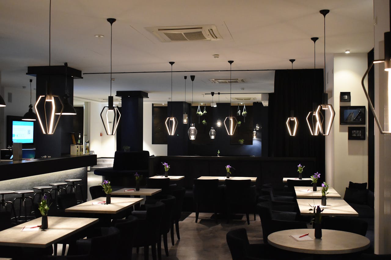 Bistrot &eacute;l&eacute;gant avec mur bleu fonc&eacute; et luminaires dor&eacute;s